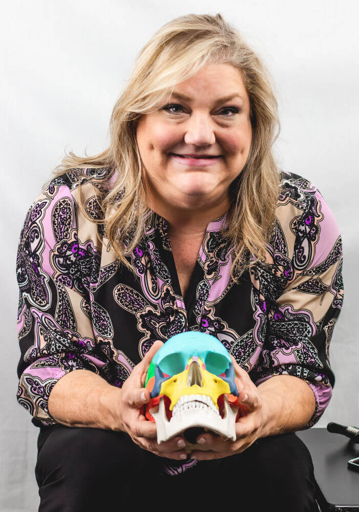 Dr. Cynthia Seebacher, DC holding a demo skull with color blocking